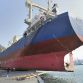 People are dwarfed by a freighter that sits on a breakwater in Kamaishi in Iwate Prefecture Sunday.  Photo Credit: AP