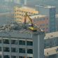 Taiyuan excavator working on top of 12 story building